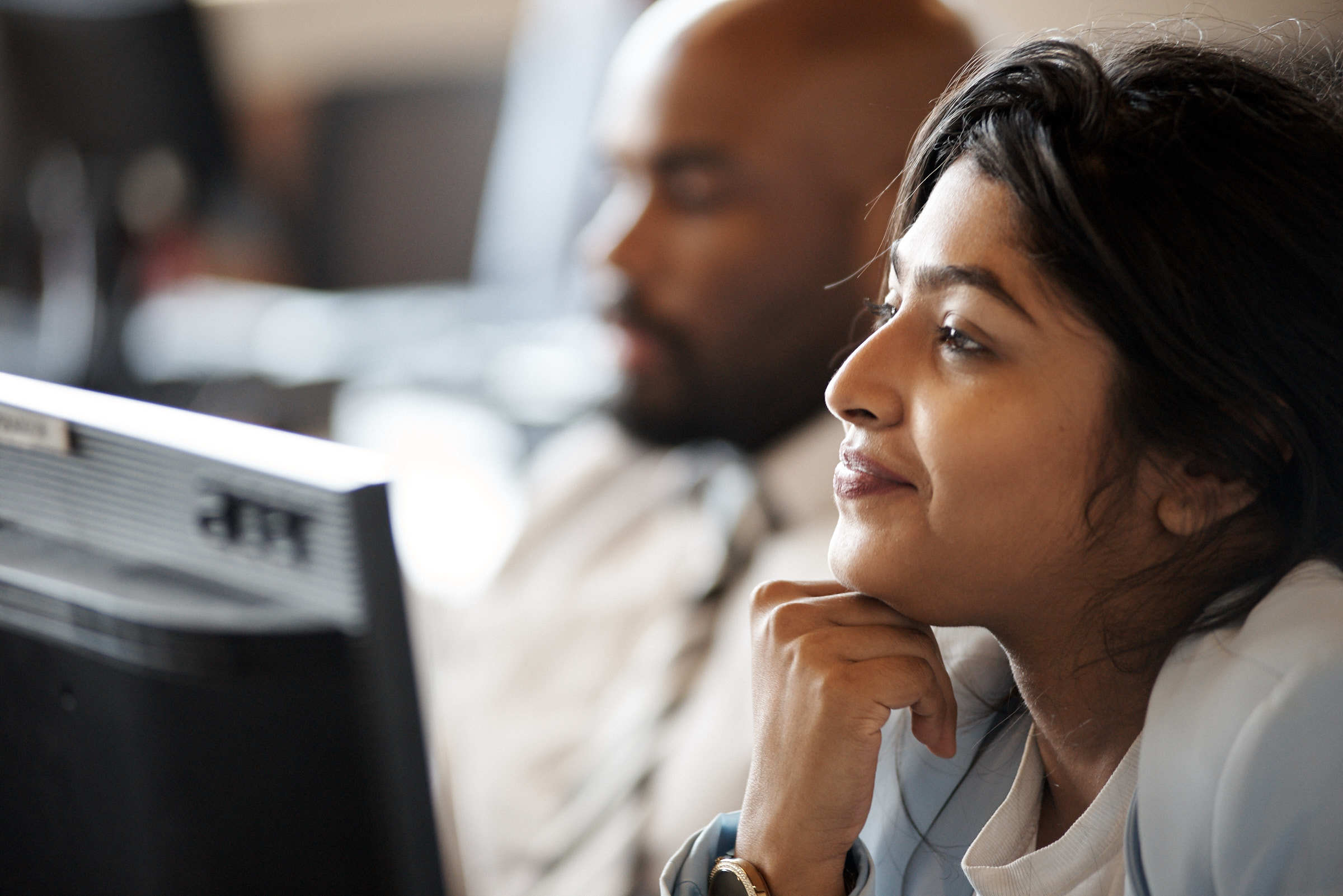 Two adults attentively looking at a computer screen.
