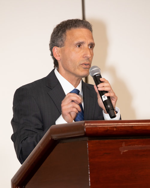 Man speaking into a microphone at a podium.
