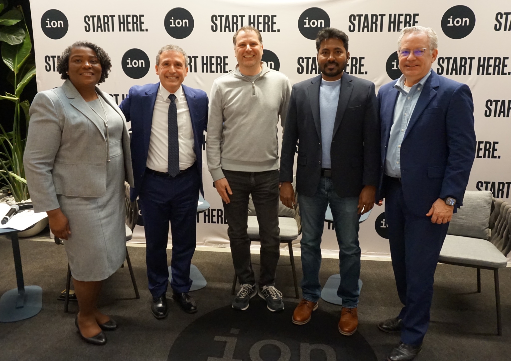 Five people stand side-by-side smiling in front of a backdrop that reads "ion" and "START HERE."