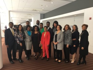 A diverse group of adults standing together in a conference hallway, smiling for a group photo.