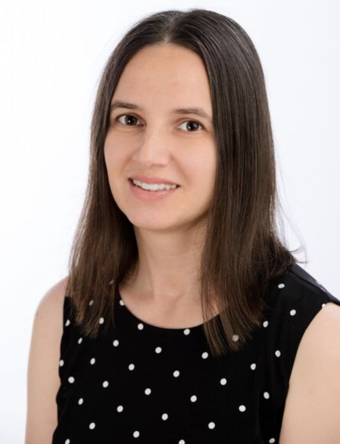 Head-and-shoulders portrait of a smiling adult woman, facing the camera.