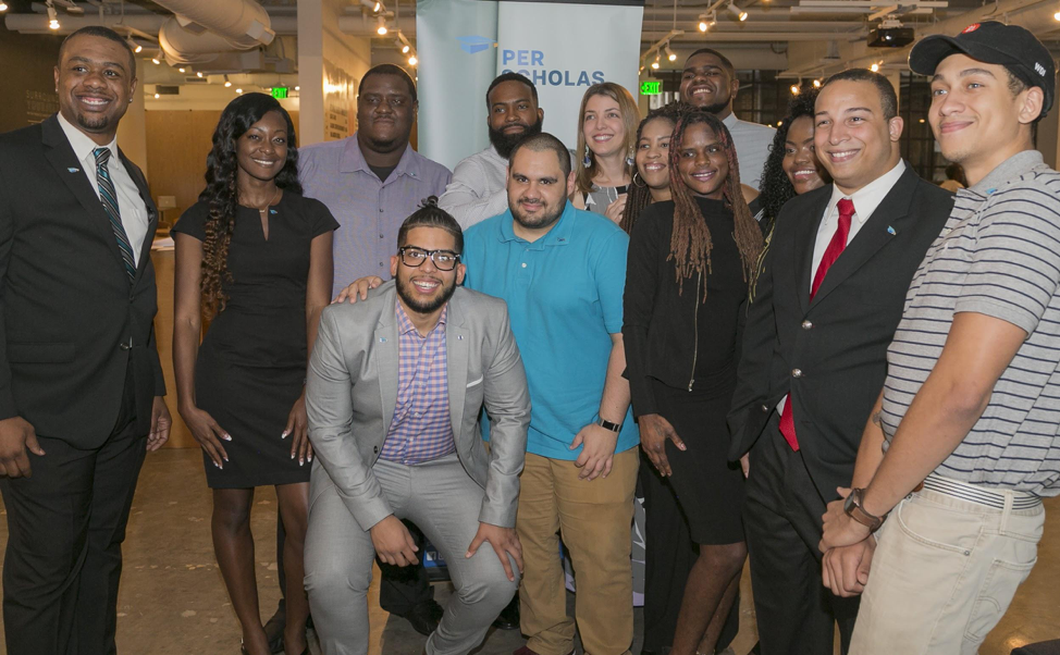 A diverse group of adults smiling for a photo together at a Per Scholas event.