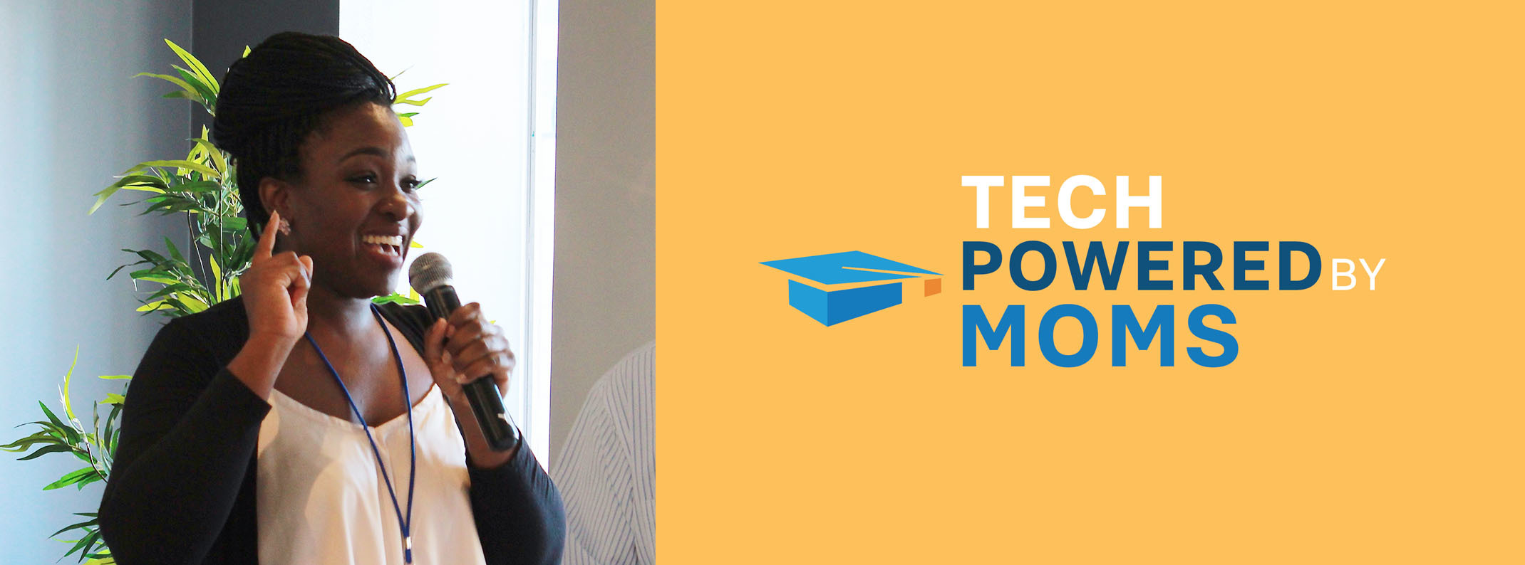 Woman speaking into a microphone adn smiling while gesturing, next to the "Tech Powered By Moms" logo on a yellow banner.