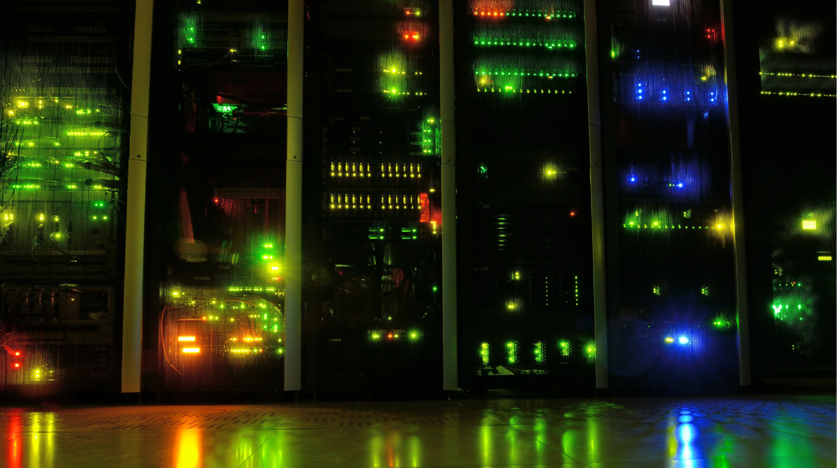 Server racks with blinking status lights in a dim data center, reflecting on the floor.