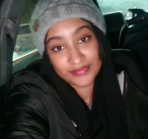 alumni sitting in car with a grey hat