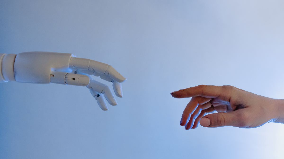 A robotic hand and a human hand reaching toward each other.
