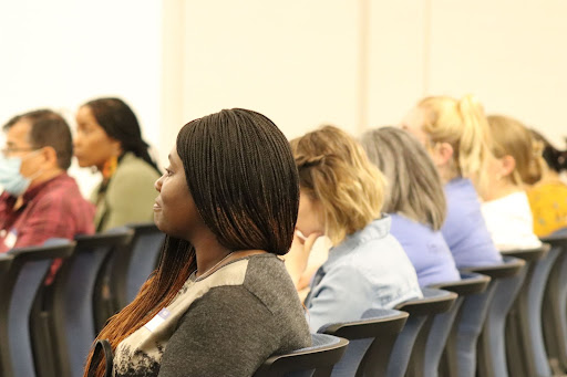 Adults seated in rows listening attentively.