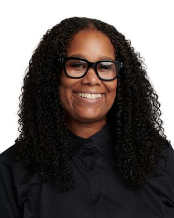 Camisha Beverly smiling, wearing glasses in a headshot.