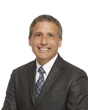 Headshot of Plinio Ayala smiling, in a suit and tie.