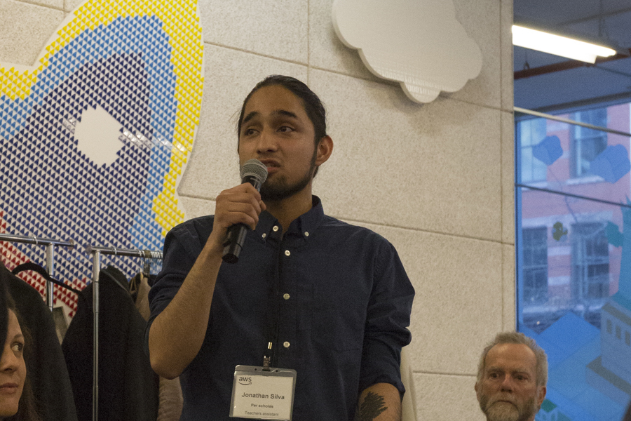 Man speaking into a microphone, wearing a name badge that reads Jonathan Silva.