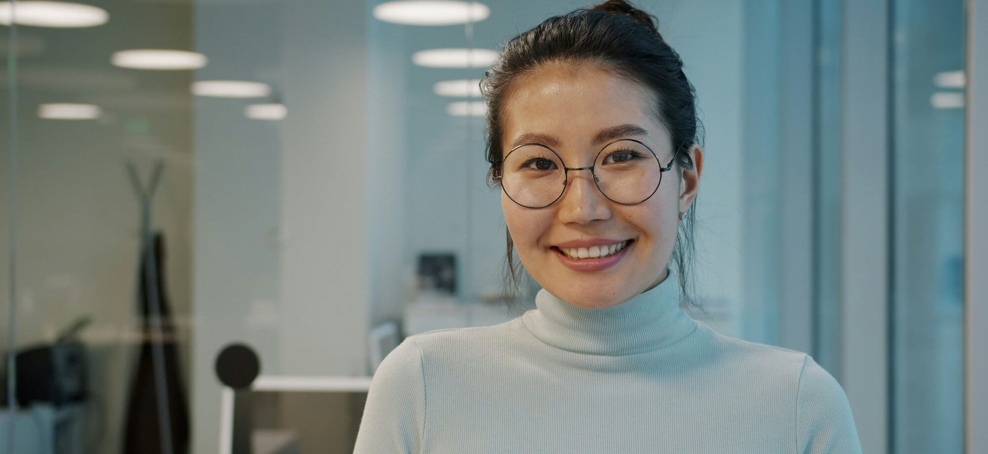Woman smiling with glasses in an office setting