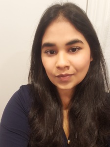 Woman with long dark hair looking at the camera with a neutral expression.