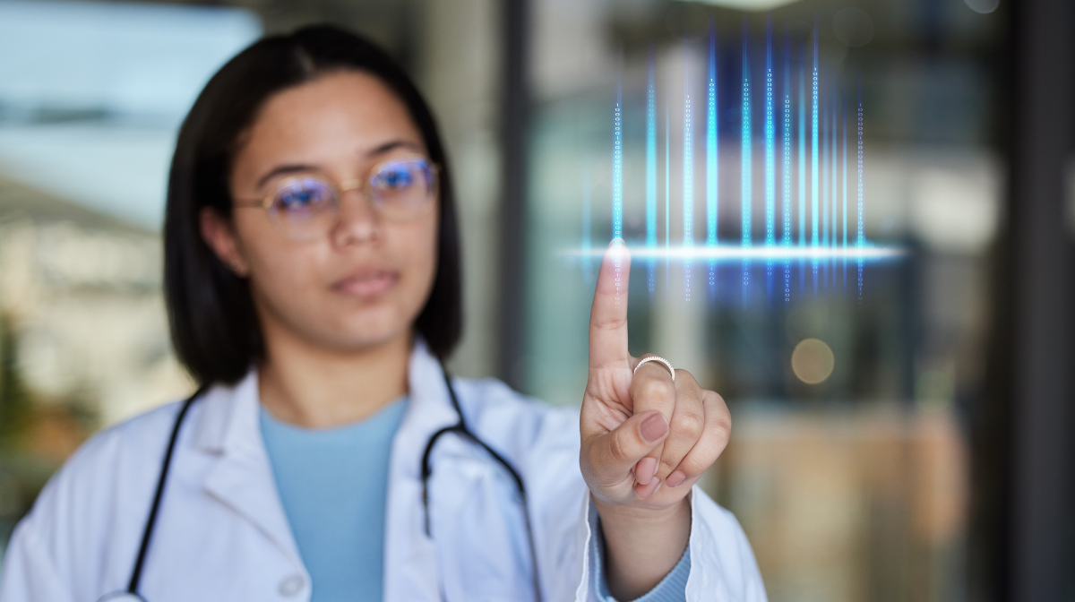 Young woman in glasses, a lab coat and stethoscope taps a floating digital waveform.