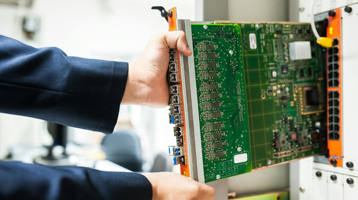 Technician inserting a server circuit board from a data center rack.