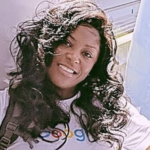 Smiling adult woman, facing camera in an outdoor setting.