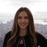 Smiling adult woman standing with a city skyline behind her.