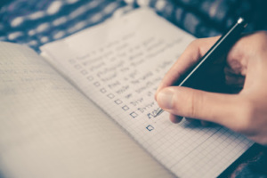 Hand writing a checklist in a notebook.