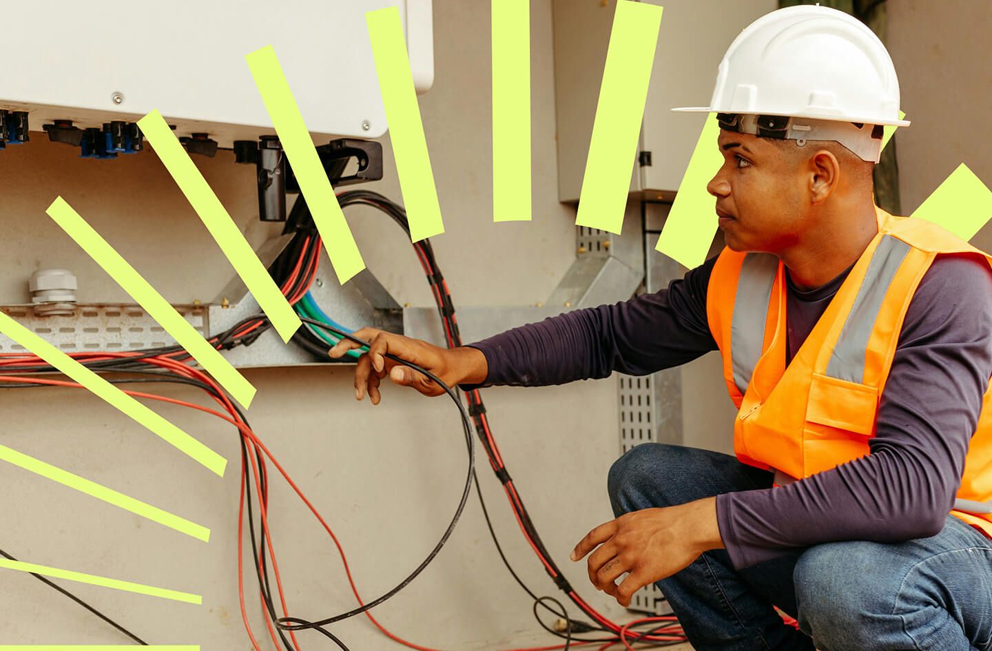 Electrical technician in a hard hat and orange safety vest inspects wiring inside a control panel, with bright rays highlighting the cables.