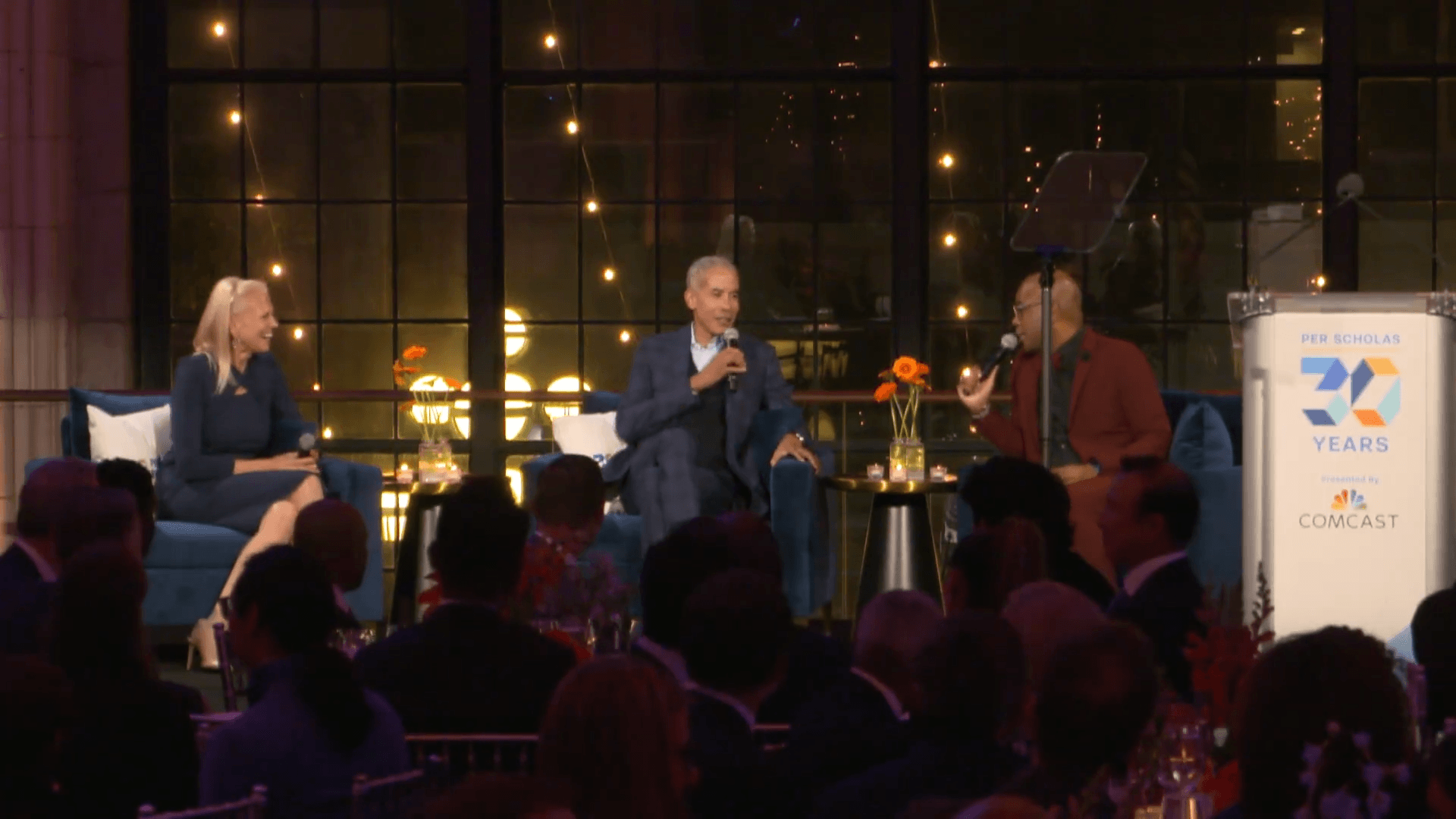 Group of speakers seated on stage at event