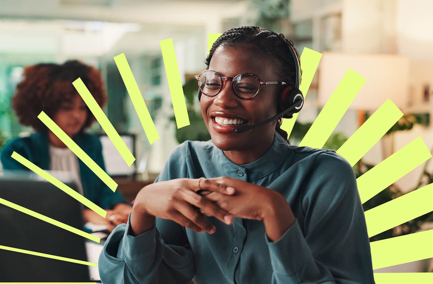 Smiling Black woman wearing glasses and a headset sits with folded hands as bright yellow rays radiate behind her, creating an upbeat tone.