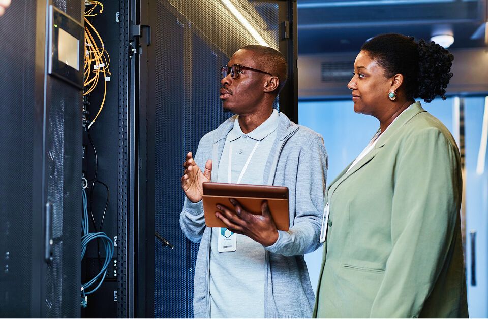 Employees working data center looking at servers