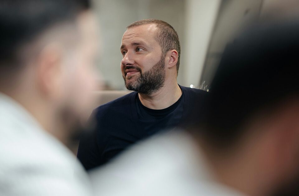 Man seated in a classroom, listening attentively.