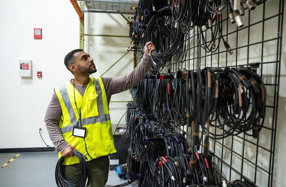 Technician organizing a wall of equipment.