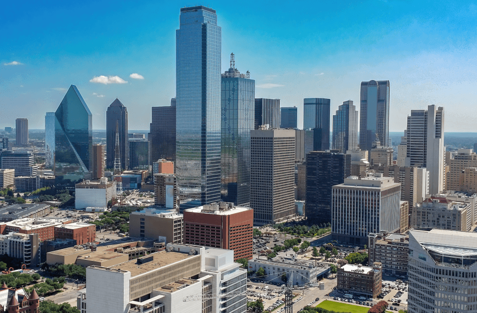 Downtown Dallas skyline featuring modern skyscrapers under a clear blue sky.