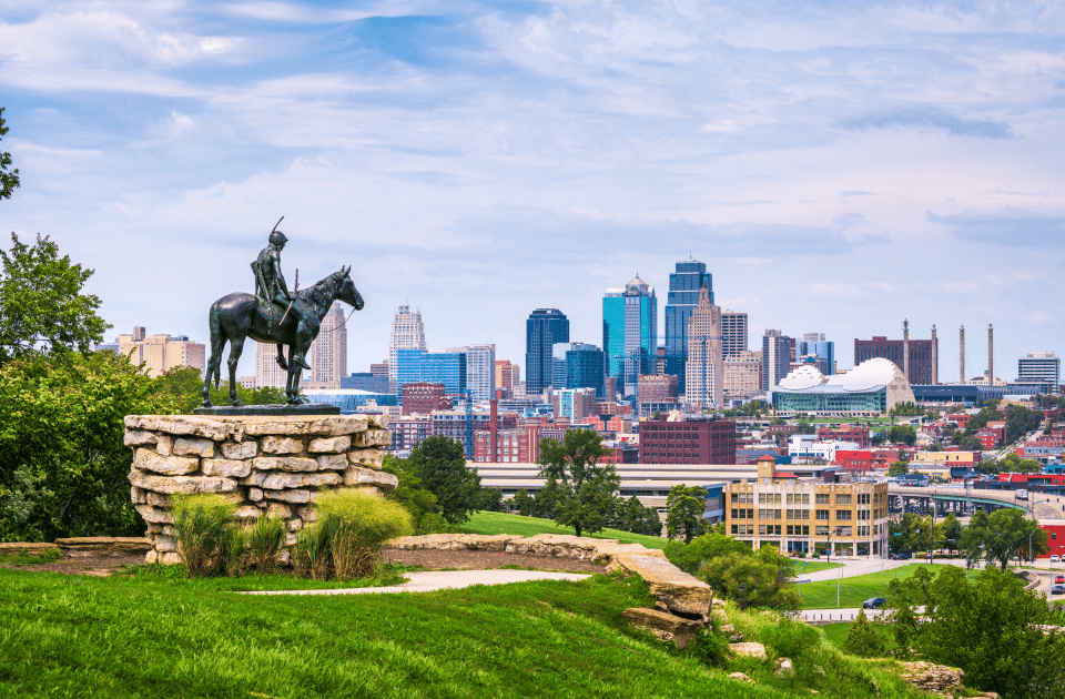 Kansas City skyline viewed from a park with an equestrian statue in the foreground.