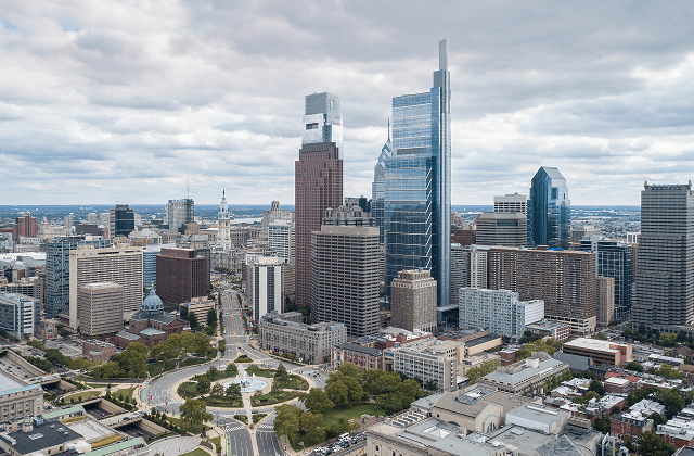 View of downtown Philadelphia featuring Comcast Center, One Liberty Place, and City Hall around Logan Circle.