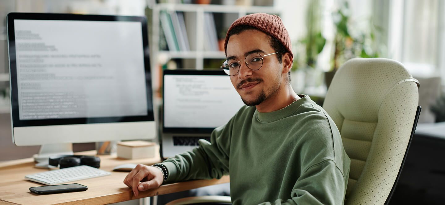 Portrait of coding engineer sitting at desk