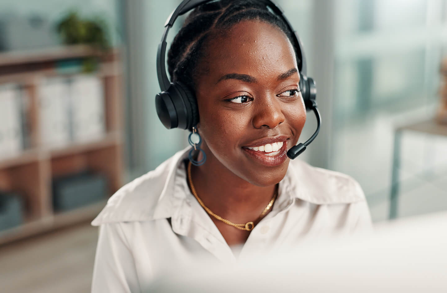 Woman with headset seated at desk in office