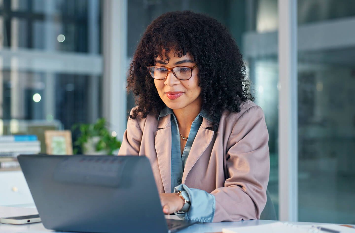 Woman in office seated at desk with laptop